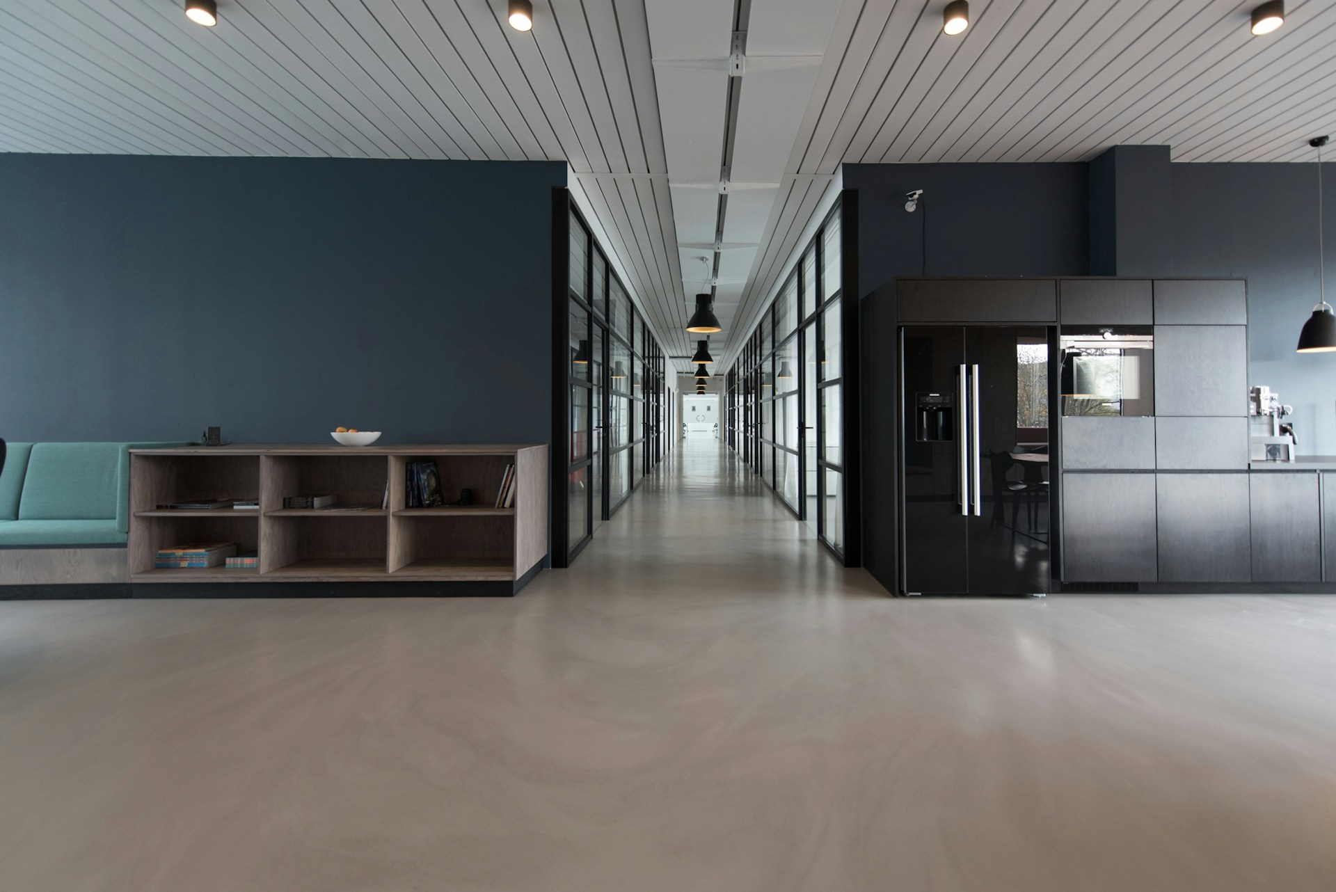Bright office corridor with glass meeting rooms